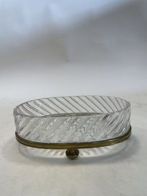 a glass bowl with a metal base on a table