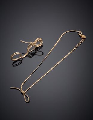 une paire de boucles d'oreilles en or et un collier en or sur fond noir