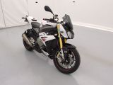 une photo d'une moto blanche et noire garée dans un garage