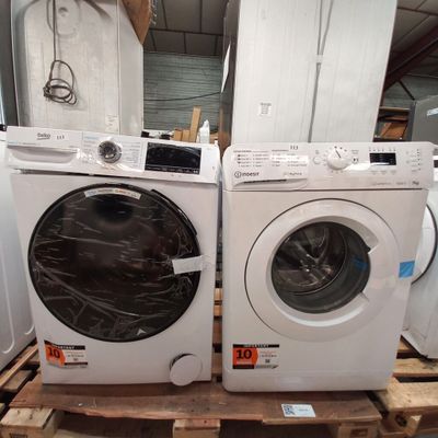 deux lave-linge et un sèche-linge posés sur une palette dans un entrepôt
