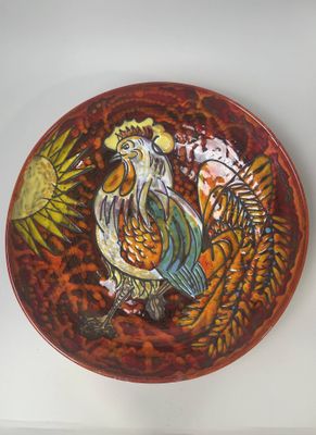 une assiette décorative représentant un coq, posée sur une table