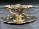 a silver plate with a bowl on it on a table