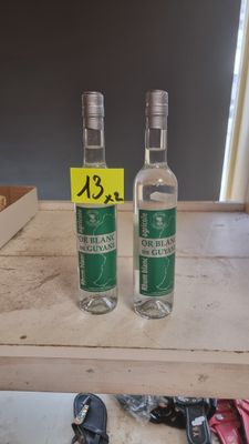 two bottles of alcohol sitting on a table with shoes