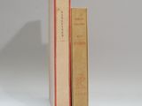 deux livres sont empilés l'un sur l'autre sur une surface blanche