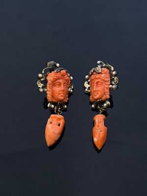 an image of a pair of earrings with a face on them