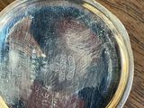 a close up of a silver plate on a wooden table
