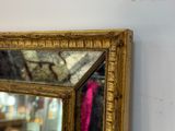 un miroir accroché au mur, sur lequel est posé un foulard rose