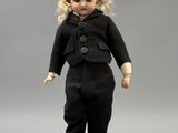 an image of a doll of a little girl in a black suit
