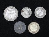 quatre types différents de pièces d'argent sur un fond noir