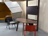 une petite table avec une chaise rangée dessous, dans une pièce