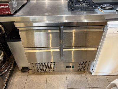 stainless steel counter top in a commercial kitchen with a stove and dishwasher