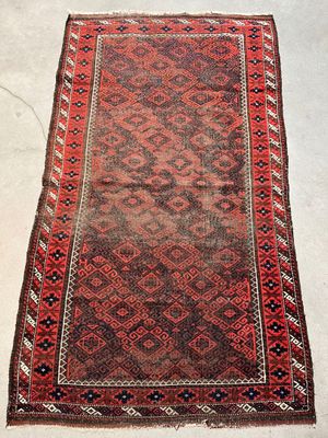 a red and black rug sitting on top of a white floor