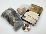 une petite boîte remplie de pièces posée sur une table, à côté d'un livre