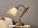 une petite table sur laquelle est posée une lampe, à côté d'une chaise