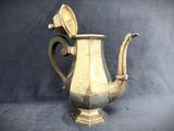 an old silver tea pot with a handle on a blue background