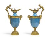 paire de vases bleus et dorés ornés de figurines sur des socles