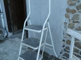 un petit tabouret blanc près d'un mur de briques