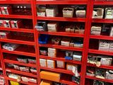 une étagère rouge sur laquelle sont empilées de nombreuses boîtes