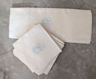 trois serviettes blanches ornées de monogrammes bleus et d'un monogramme
