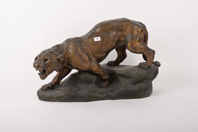 statue d'un lion assis sur un rocher, avec une étiquette sur la poitrine
