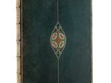 un vieux livre vert dont la couverture est ornée d'un motif décoratif