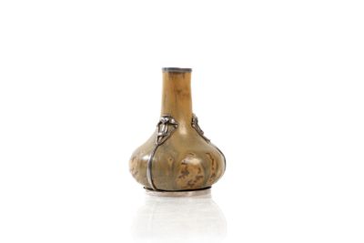 a small glass vase with a handle on a white surface