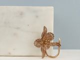 a white marble surface with a gold metal hook on it
