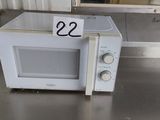 a white microwave sitting on a table with a price tag on it