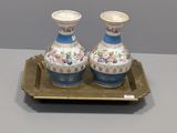 deux vases posés sur un plateau posé sur une table