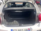 the back of a white car with its trunk open in a parking lot
