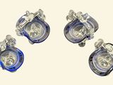 four pieces of blue and clear glass are arranged on a white surface