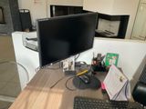 un bureau sur lequel se trouvent un écran, un clavier, une souris et d'autres éléments