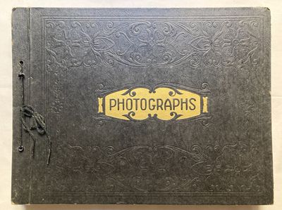 un vieux livre noir avec un logo doré sur la couverture