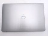 dell laptop computer sitting on a white surface with a logo on the screen