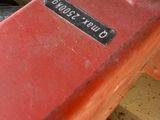 a close up of a red skateboard with a sticker on it