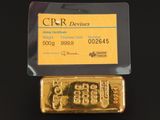 un lingot d'or et une carte de crédit posés sur une surface noire