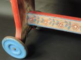 a wooden toy car with a blue wheel on a black surface