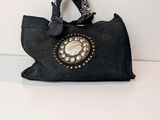 a black purse with a phone on it on a table