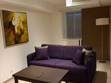 a purple couch sitting in a living room next to a coffee table