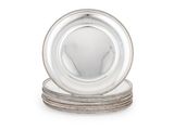 une image représentant une assiette en argent posée sur une pile d'assiettes en argent