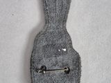 a small gray bag with a metal pin on it