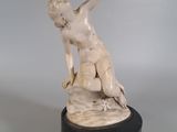 statue d'une femme assise sur un rocher, tenant un oiseau dans la main