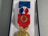 an image of a medal in a box with a ribbon around it