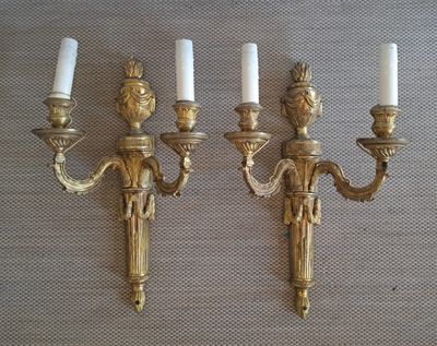 pair of antique brass wall sconces with white candles