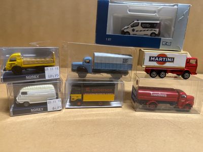 five different models of toy trucks in a display case