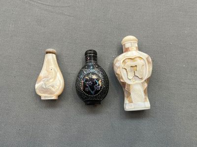 trois objets sculptés sont posés sur une surface grise