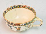 a small cup with a handle on a white table
