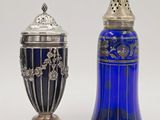 une paire de salières et poivrières en verre bleu sur fond blanc