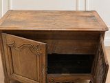 une petite table en bois dont la porte est ouverte et repose à même le sol