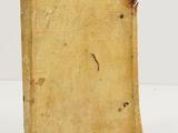 un vieux livre posé sur une table à côté d'un mur blanc